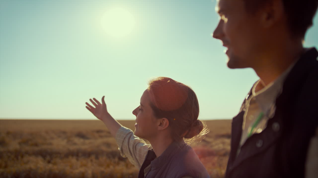 농부 는 농장 을 가 ⁇ 게 보여주고 있다. 농업 업계 팀 이 밀 작물을  ⁇ 고 있다.