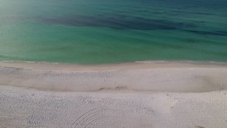 pan on a white sand beach with emerald waters on a summer day