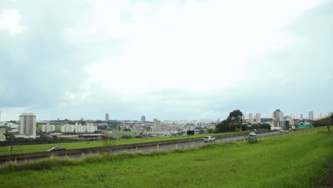 Vehicles-traffic-in-a-road-at-Franca,-country-side-city-with-many-buildings-at-back-and-a-beautiful-view---Pan-Shot