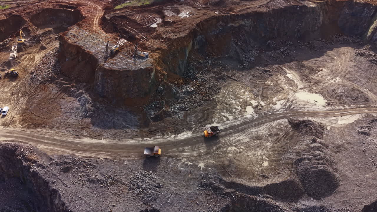 Granite quarry showing large excavation area with vehicles working during daylight hours