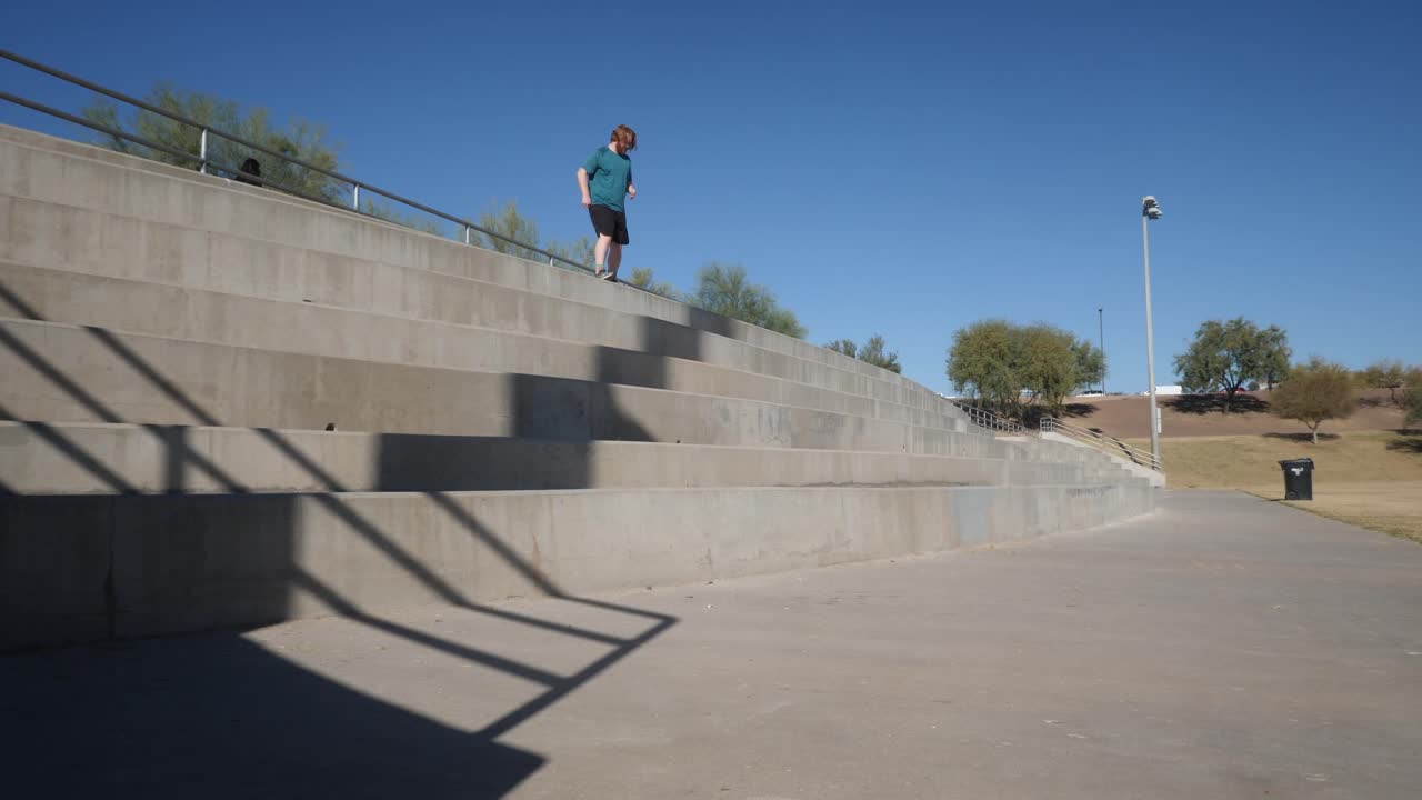 el hombre pelirrojo corre por las escaleras de cemento mientras hace ejercicio.
