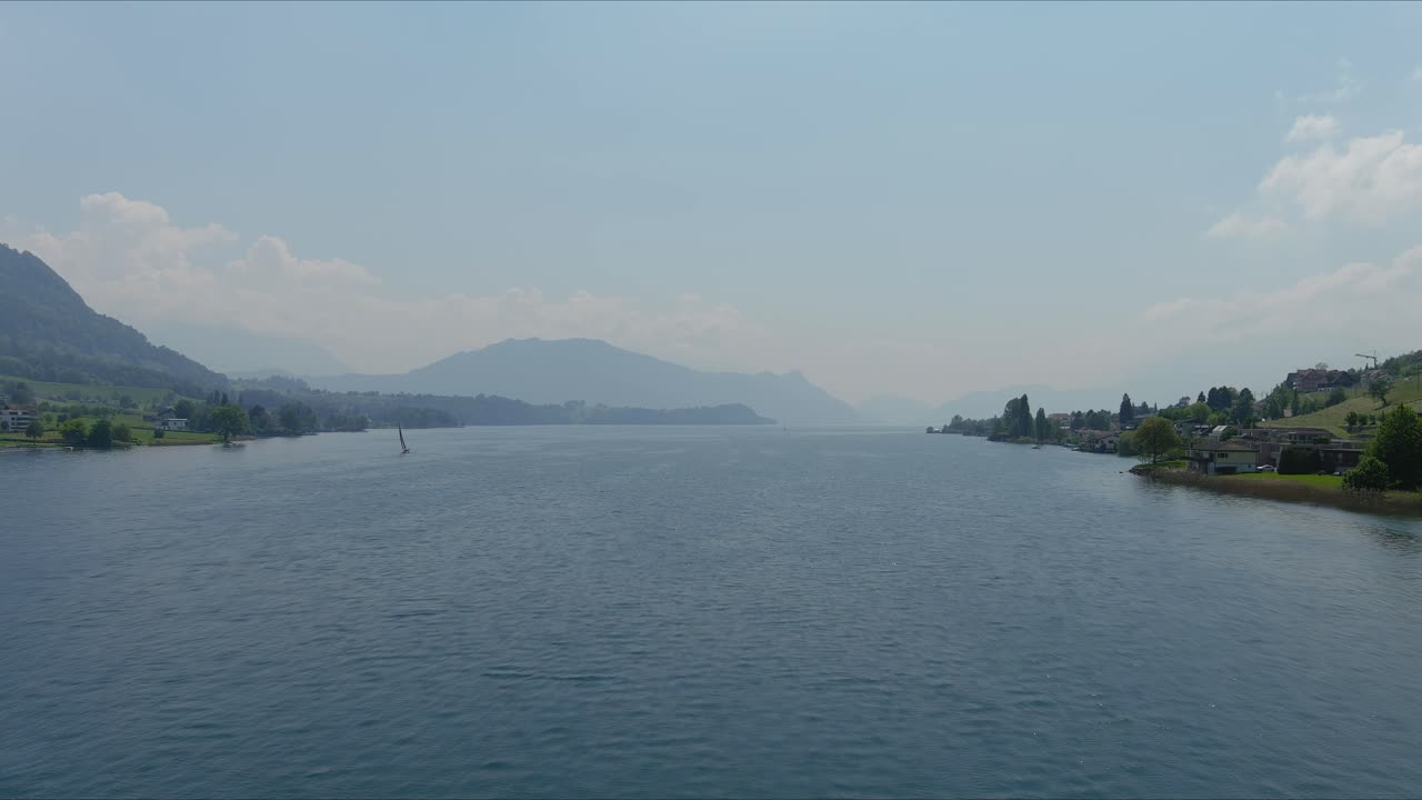 쿠스나흐트 플라이오버: 알프스 산맥의 경치 좋은 물 계곡과 마을을 가로질러 이동, 스위스, 유럽, 드론 | 거대한 호수와 시골에 있는 작은 집들의 극적인 영화적 접근  ⁇