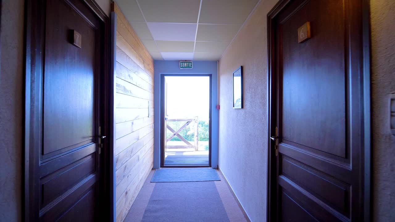 Fast moving interior view of long corridor with rooms, outside view of green garden