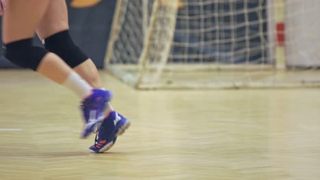 Las-Piernas-De-Una-Jugadora-Con-Rodilleras-Sirviendo-En-Una-Cancha-De-Voleibol