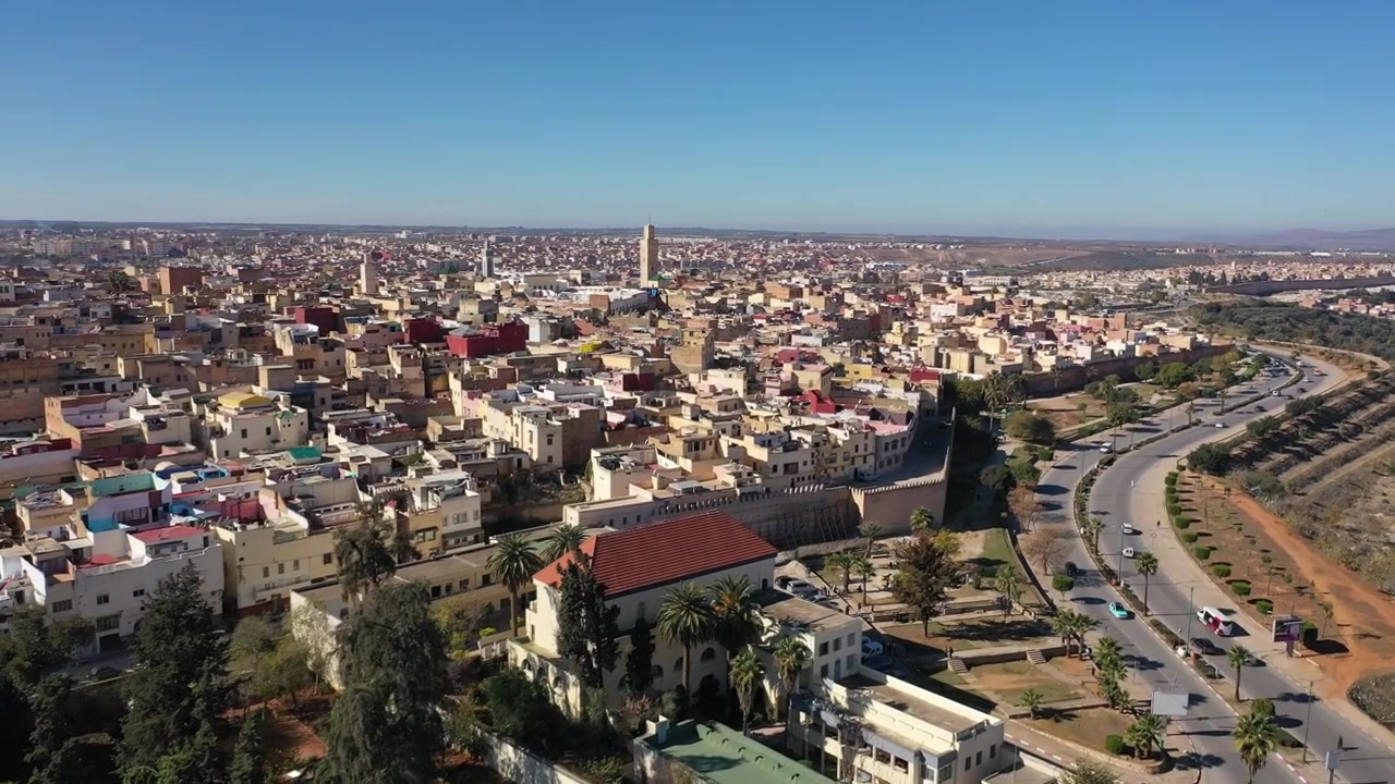 Veduta aerea con drone di Meknes, una delle quattro città imperiali del Marocco e una destinazione Patrimonio dell'Umanità UNESCO. La scena evidenzia gli spazi verdi della città, il paesaggio urbano storico, il patrimonio culturale