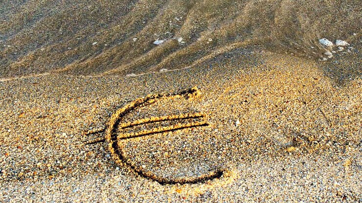 Simbolo dell'euro sulla sabbia. Sabbia e valuta