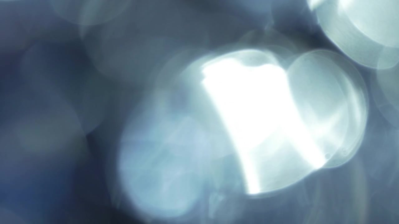 Æteriske lysglimt og bokeh, der bevæger sig på sort baggrund