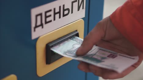persona que inserta dinero en una máquina de pago