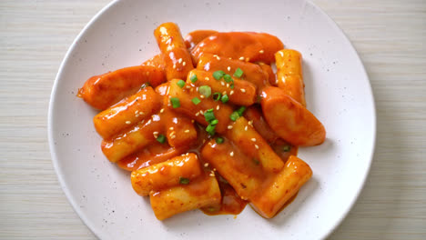 korean rice cake stick with sausage in spicy sauce - tteokbokki