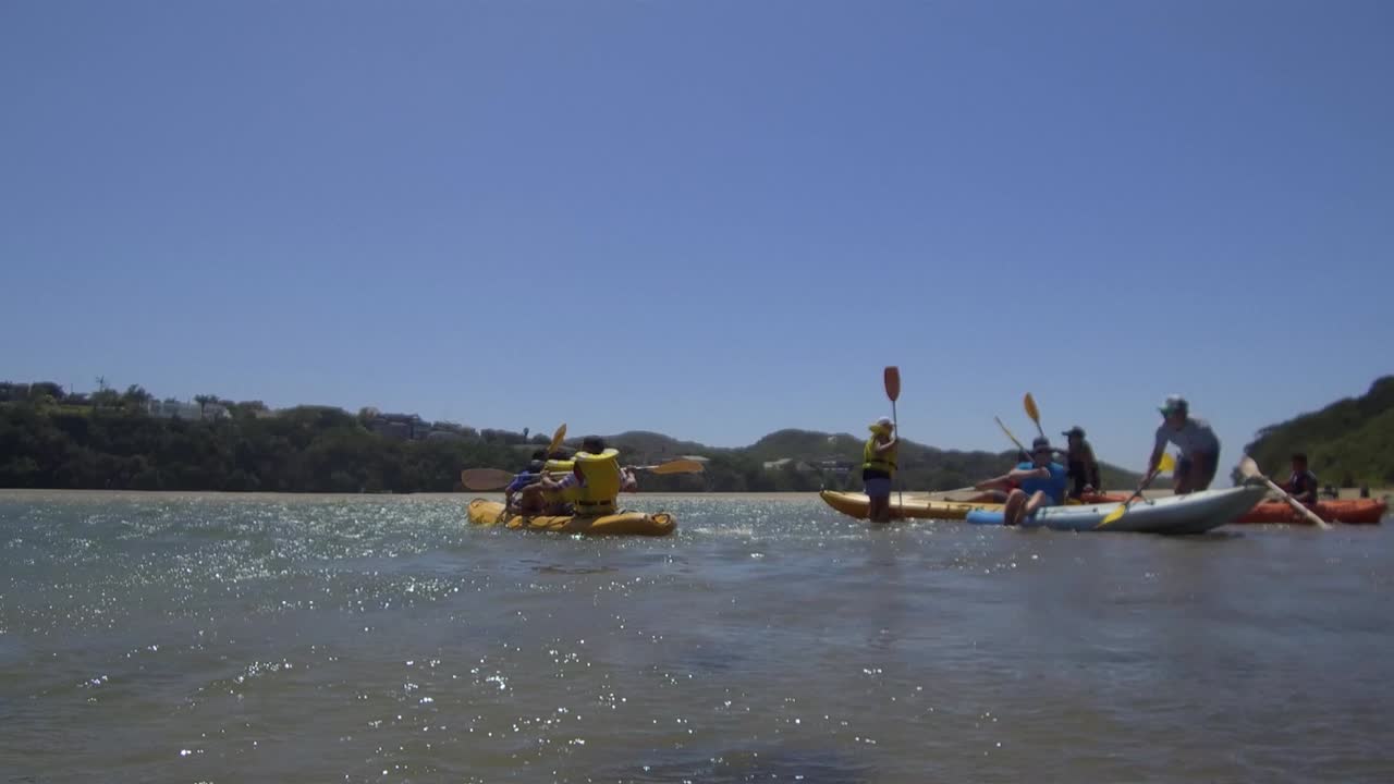 ángulo del nivel del agua de los adolescentes en canoa por el río nahoon en el este de londres, sudáfrica