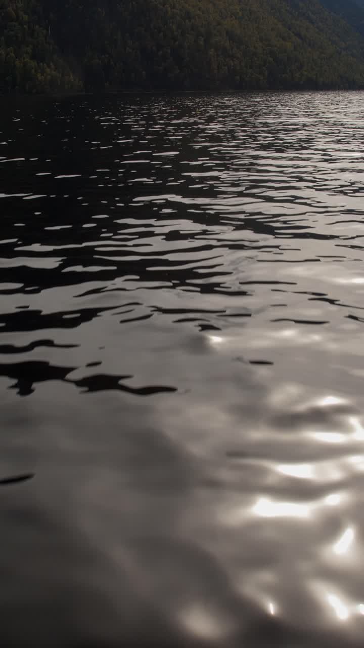 Reflective water surface with gentle ripples and shimmering highlights, creating a tranquil and serene atmosphere for nature and relaxation themes