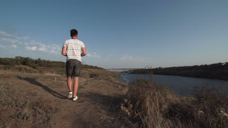 man flying a drone over a river landscape