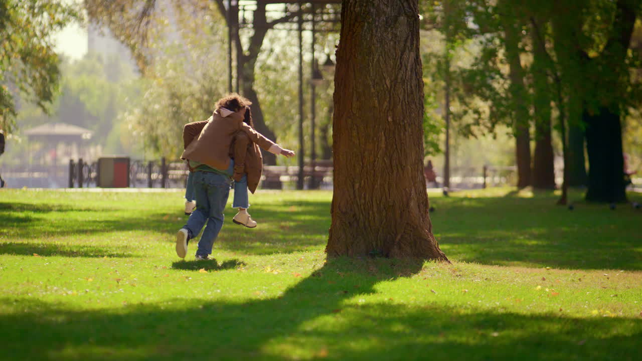 un padre feliz llevando a su hija en el parque de sunny spring, un padre amoroso el fin de semana.
