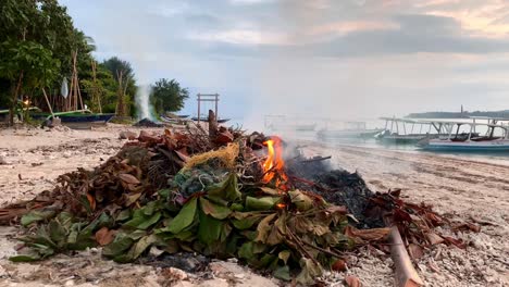 quemando basura plástica y arrojando basura en una hermosa playa en la isla gili air