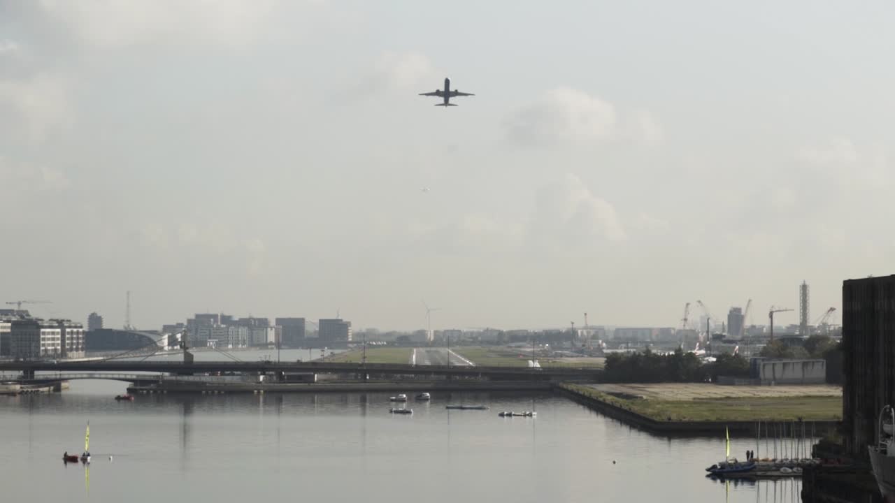 도시 와 강 위 에 착륙 하는 비행기