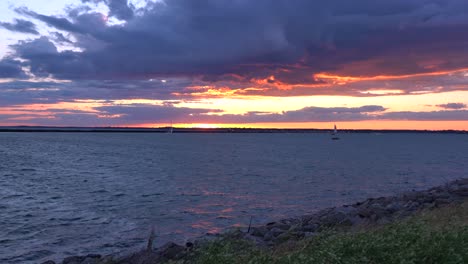 Ein-Sonnenuntergang-über-Dem-Eriesee-Mit-Einem-Segelboot,-Das-über-Das-Wasser-Segelt