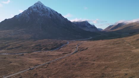 glencoe con pico de montaña cubierto de nieve y carretera sinuosa en las tierras altas de escocia, naturaleza serena