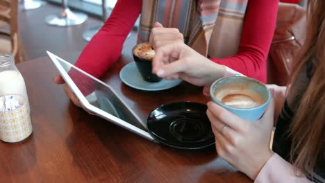 pretty friends enjoying coffee in cafe