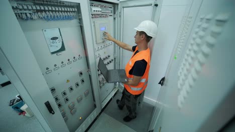 electrical engineer working check the electric current voltage and overload at front of load center cabinet or consumer unit for maintenance in main power distribution system room.