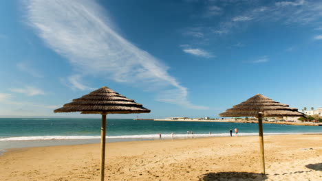 dos sombrillas de paja en la playa de santos, clima encantador con gente nadando
