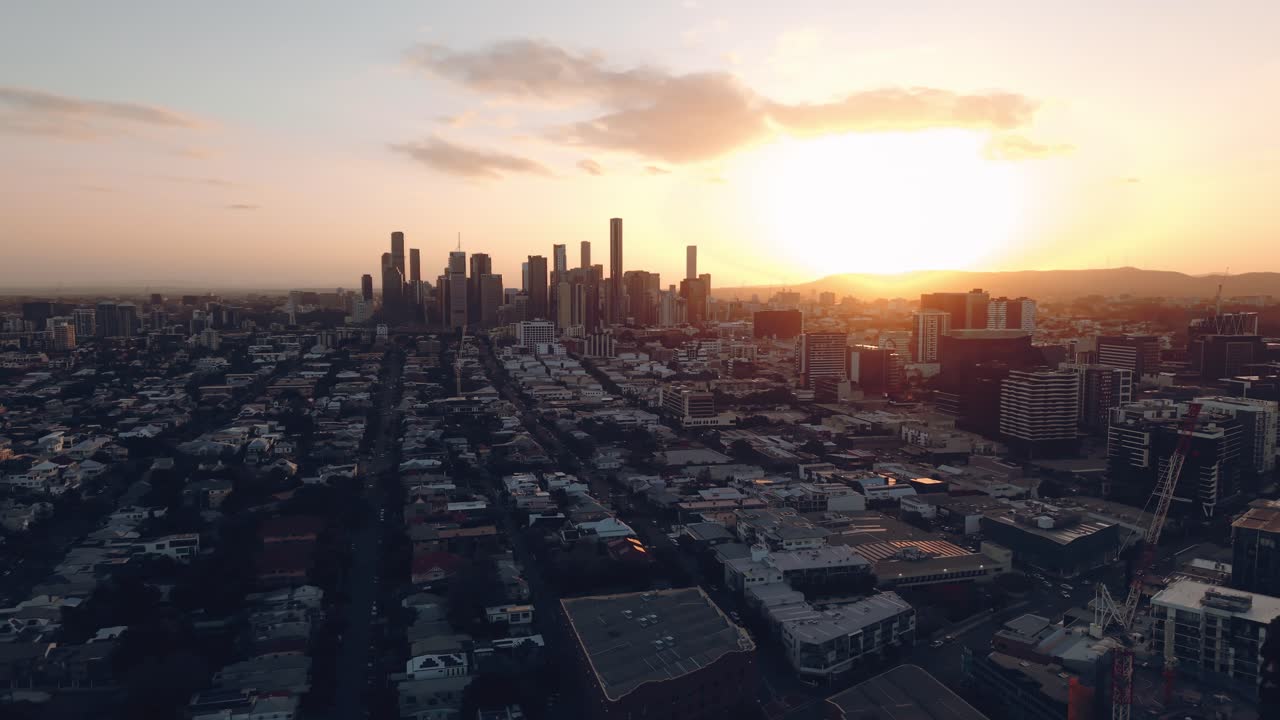 Drone sobrevoando quarteirões residenciais densamente compactados brilhando sob o céu do pôr do sol desvanecendo, CBD Teneriffe Brisbane Queensland Austrália