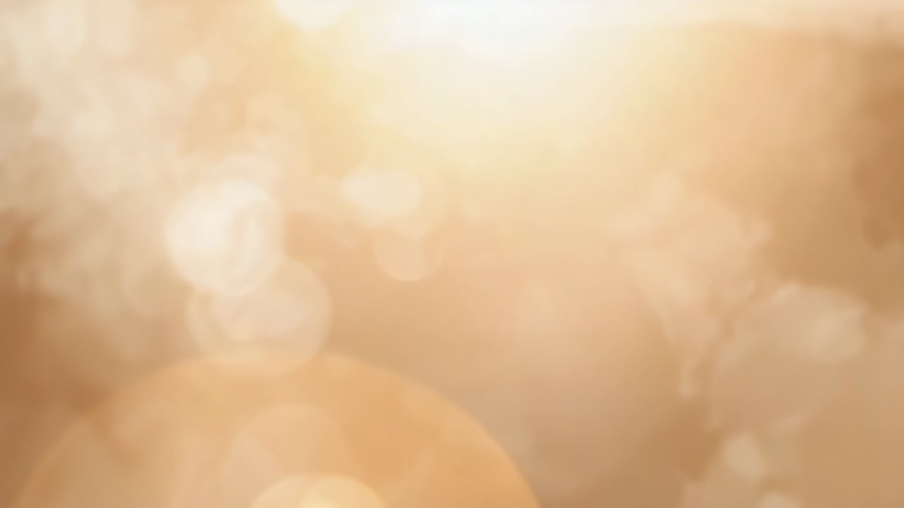 Shifting sunlight moving warm flare centering at golden-hour outside, creating warm bokeh glow