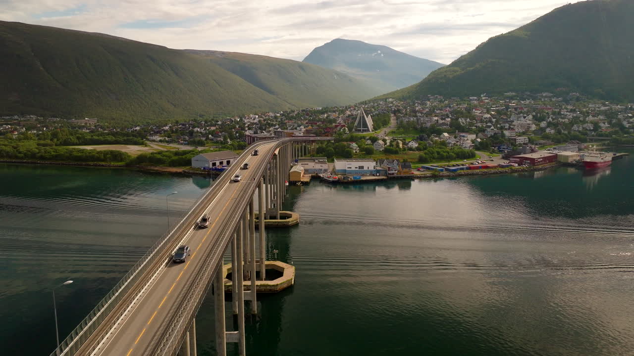 Traffic over Tromso bridge with Arctic Cathedral in back. Summer drone pullback
