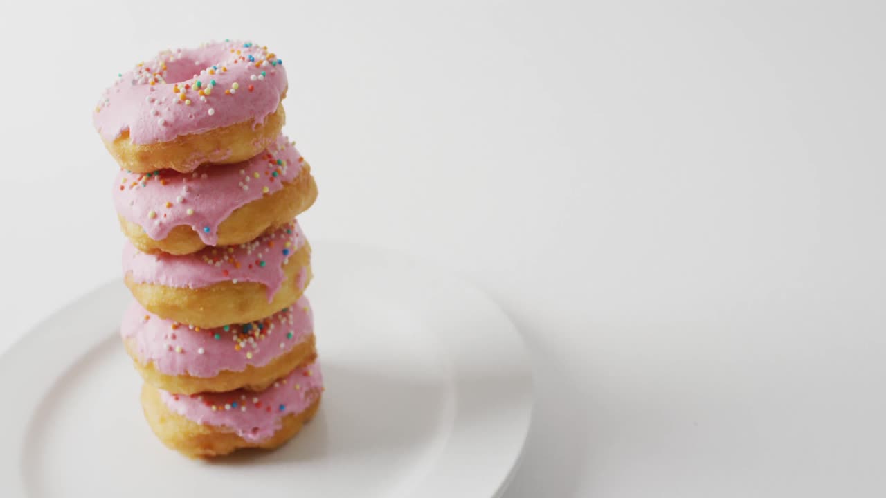 video de rosquillas con glaseado y en un plato sobre fondo blanco
