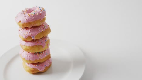 Video-of-donuts-with-icing-and-on-plate-on-white-background