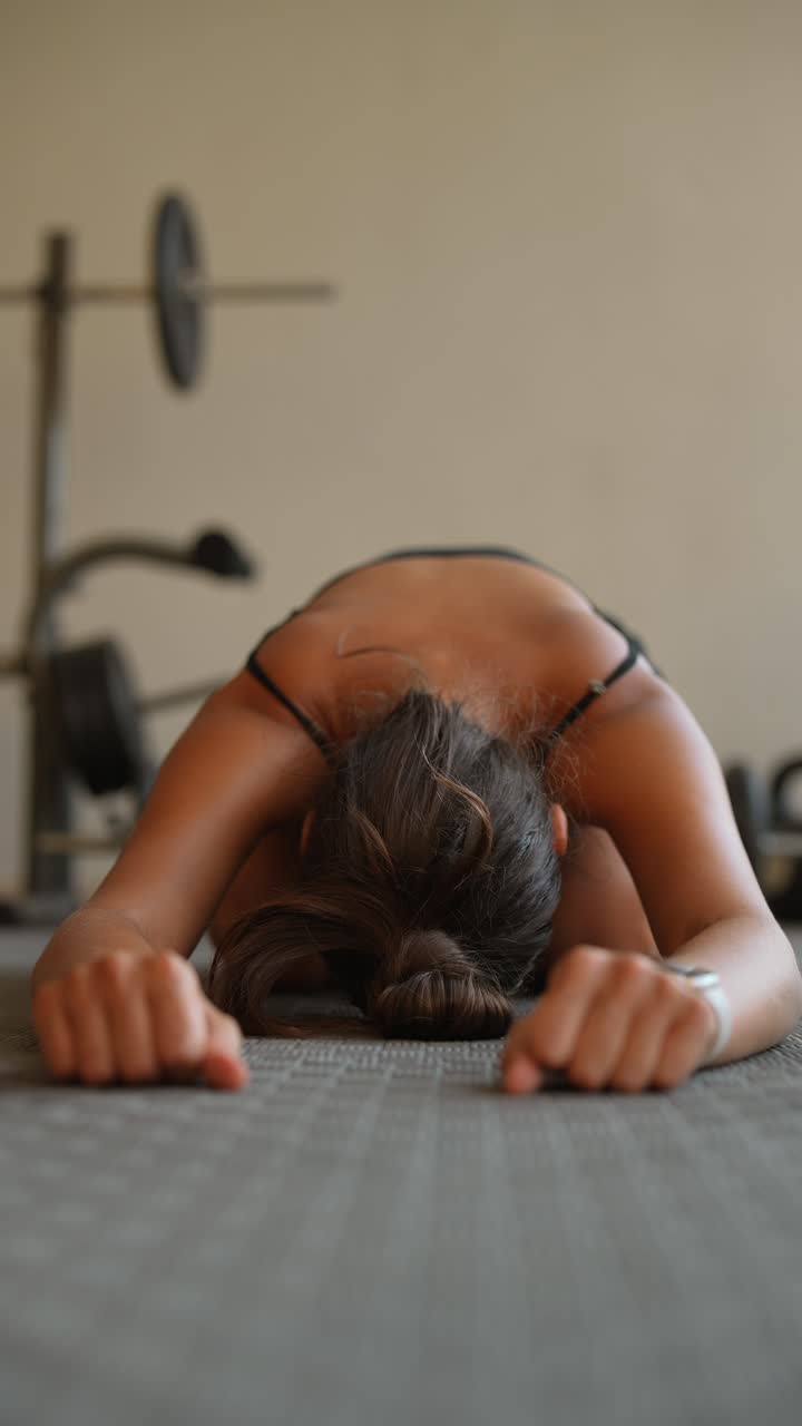 Eine Frau macht eine Plankenübung in einem Fitnessstudio