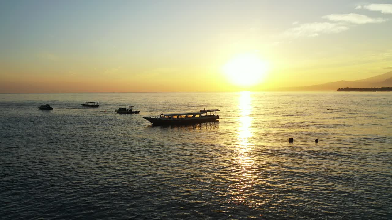 잔잔한 바다에 떠 있는 작은 어선들이 황금빛 햇살을 쬐고 있다