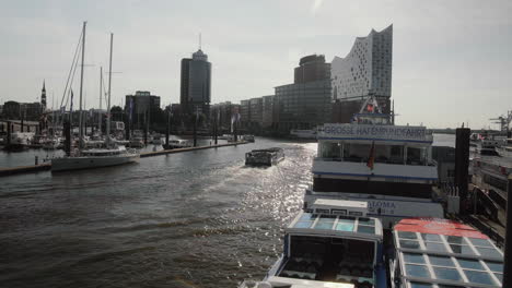 barco turístico pasando por hamburg landungsbrücken con elbphilharmonie en el fondo