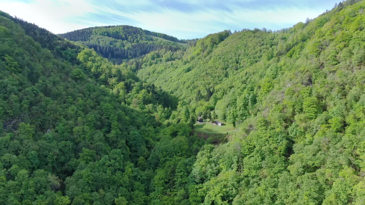Aerial shot rising among green mountains in Suhi Potok valley, Slovenia