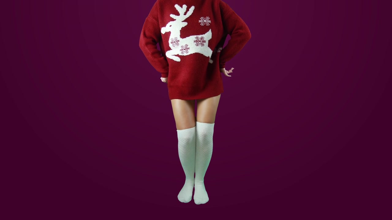 Ragazza che indossa calze bianche e balla con un maglione natalizio rosso. Incluso sfondo verde per cambio sfondo personalizzato ma anche uno sfondo bordeaux come esempio