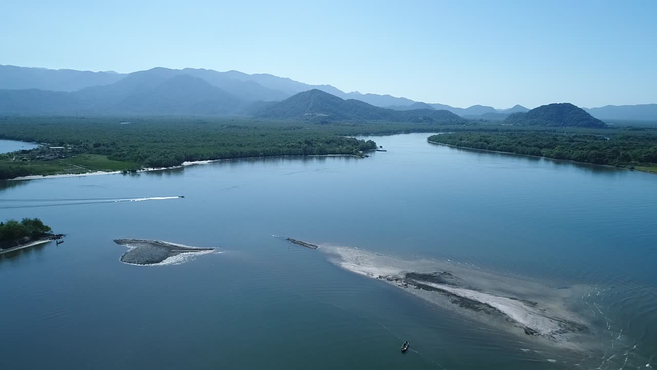 Beautiful landscape of the meeting of the sea with mangroves in Brazil, filmed with Drone, boat tracing the path of the screen, diffuse light, exuberant nature, diversity