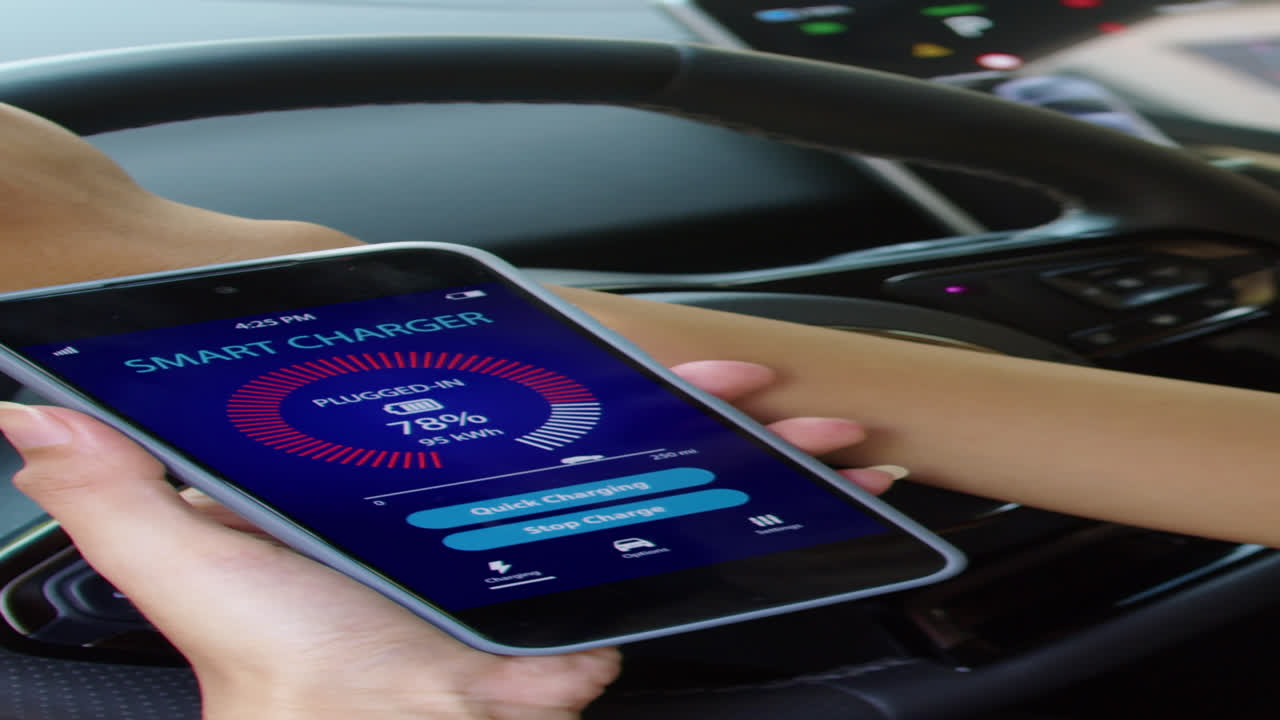 Hands of Woman Checking Charging Status on Smartphone in Car