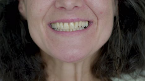 un primer plano de una mujer madura con una sonrisa dentada.