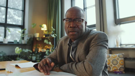senior black teacher talking at camera as giving online lesson on video call
