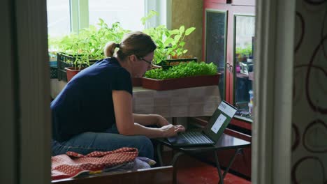 woman working from home, surrounded by potted plants