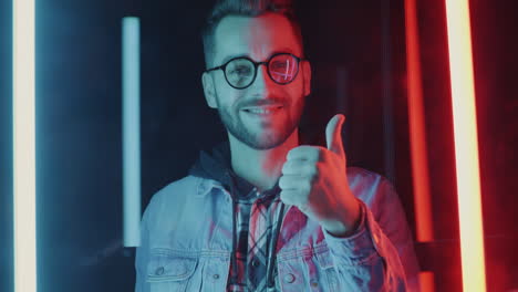 man giving thumbs up in neon lights