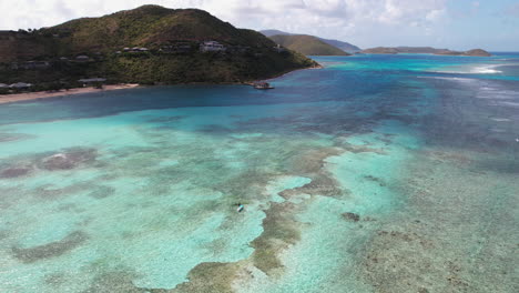 Aerial-View,-Paddleboarder-Floating-Above-Coral-Reefs-of-British-Virgin-Islands