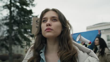 Self-confident-caucasian-woman-standing-in-front-of-group-protesting-against-Ukrainian-conflict.