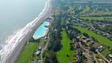 complejo costero de lujo con campos de golf, piscina gigante junto al mar, vista aérea