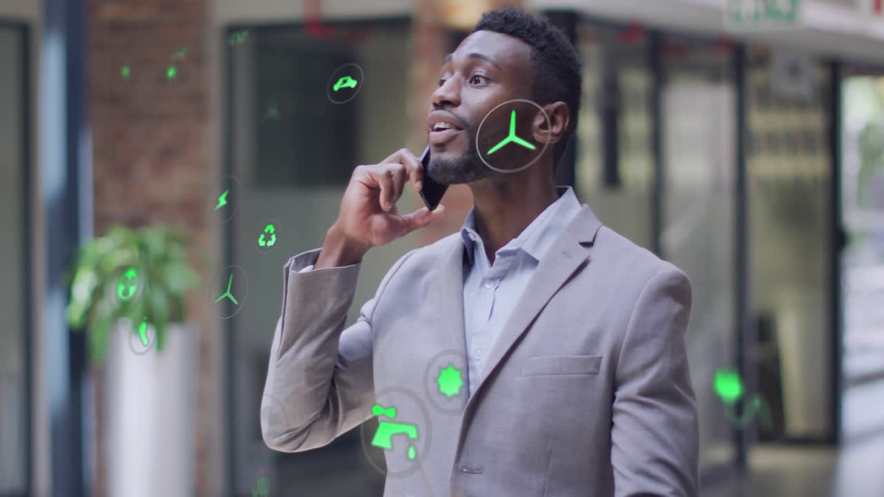 Exec taking phone call in lobby, causing green AR icons floating over him, showing energy metrics