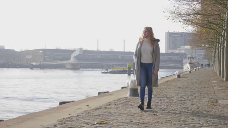 beautiful young blonde woman taking a stroll along a boardwalk