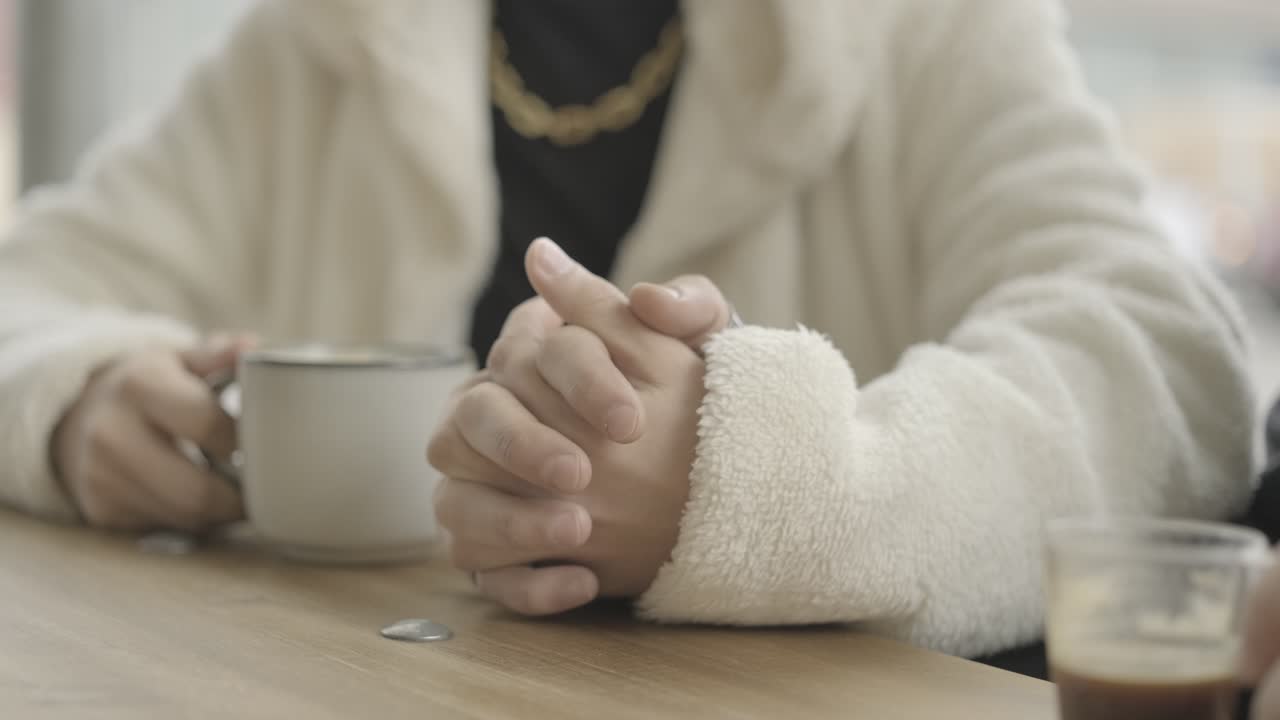Person holding a cup of coffee in a cafe