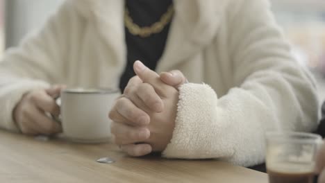 person holding a cup of coffee in a cafe