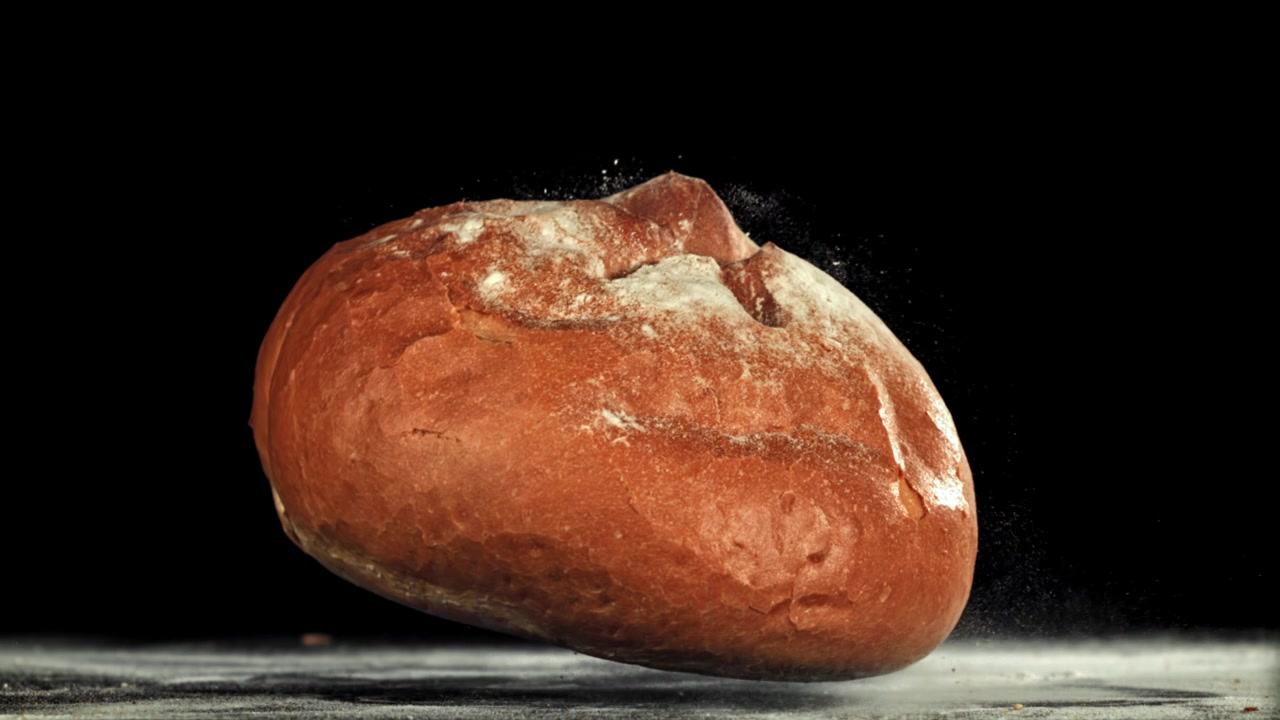 Slow Motion of Freshly Baked Bread Falling onto a Floured Surface