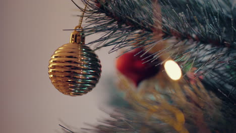 Bolas-De-Navidad-Doradas-Y-Luces-Colgando-De-Un-árbol-De-Navidad