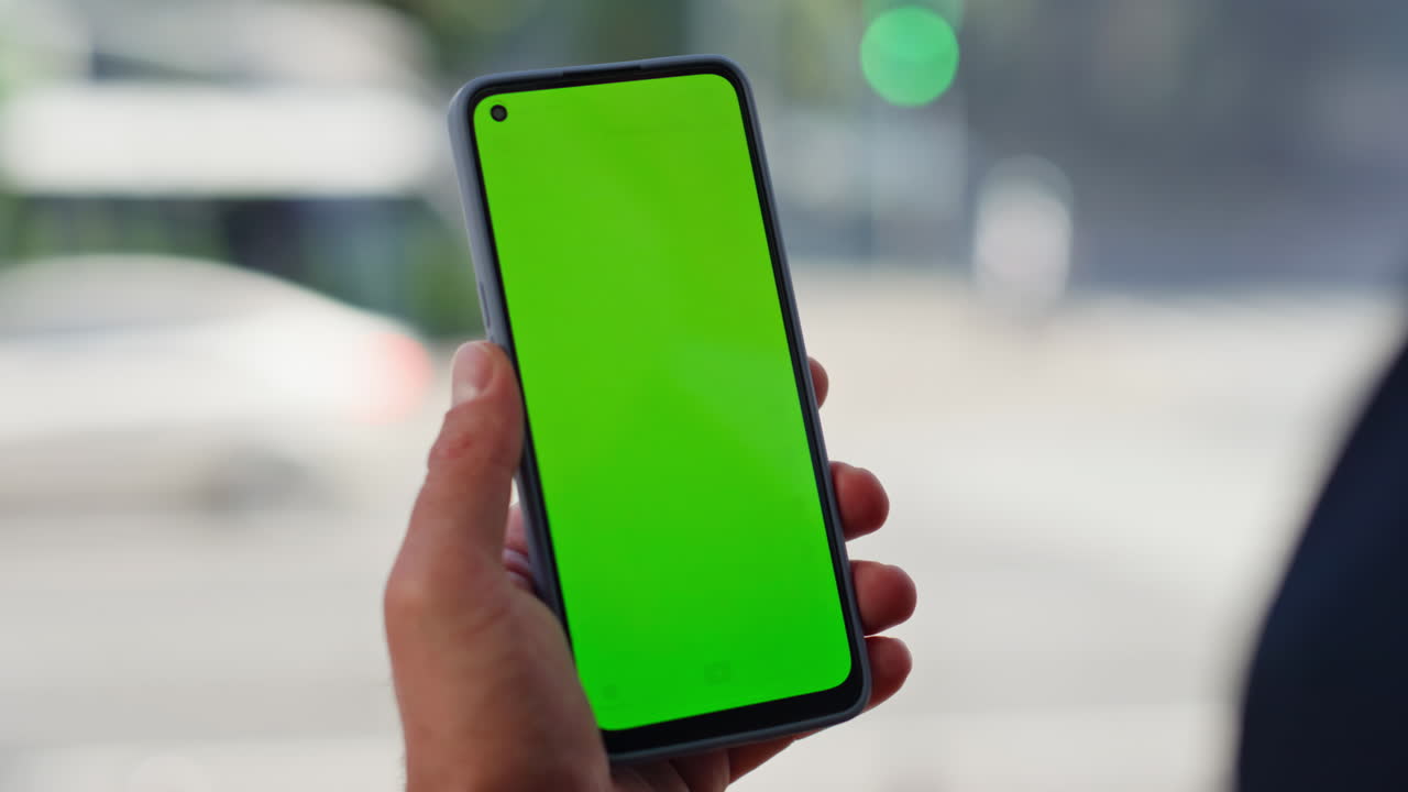 Unknown employee holding chromakey cellphone at panoramic windows room closeup